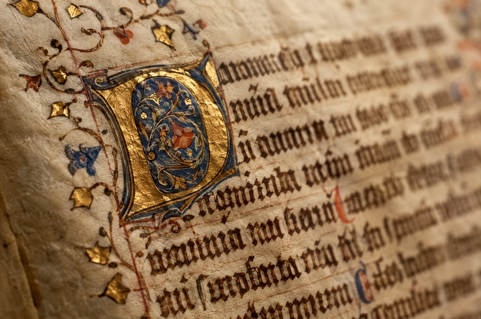 Nahaufnahme einer mittelalterlichen Pergamenthandschrift mit vergoldeter Initiale